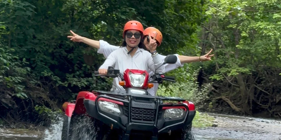 ATV tour riding through river in Playa Potrero Costa Rica jungle adventure