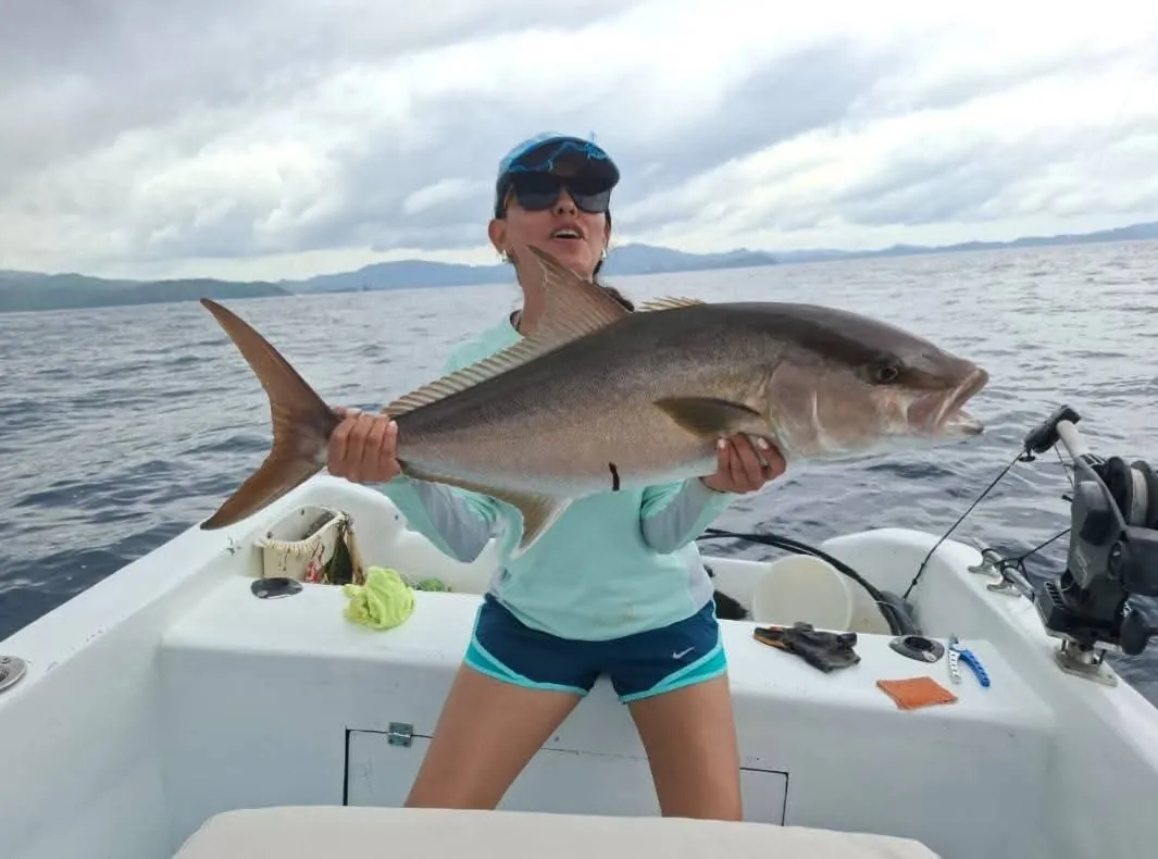Angler holding an amberjack caught offshore near Playa Flamingo, Costa Rica
