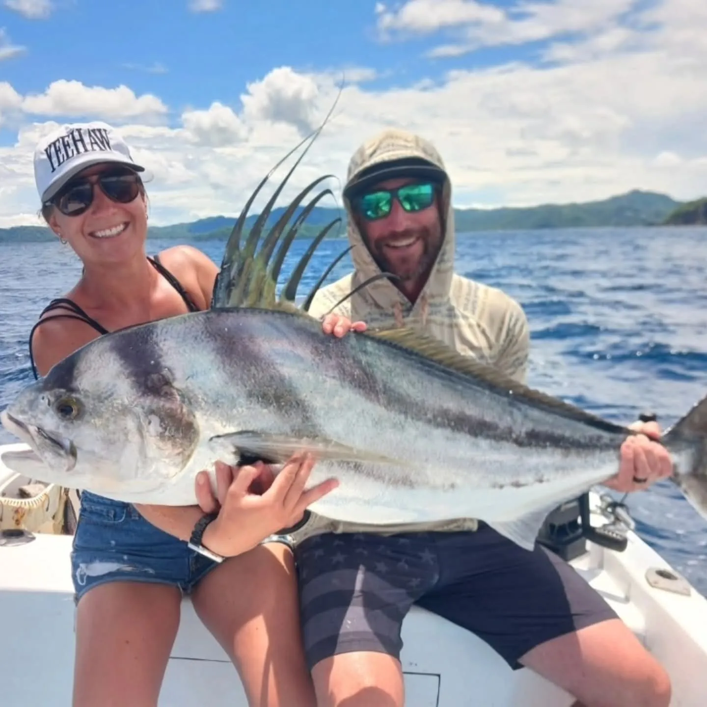 Two anglers with a rooster fish caught on a private charter in Playa Flamingo